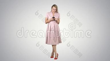 一个穿着夏季服装的漂亮微笑女孩使用手机的肖像，在<strong>渐变背景</strong>上发短信。
